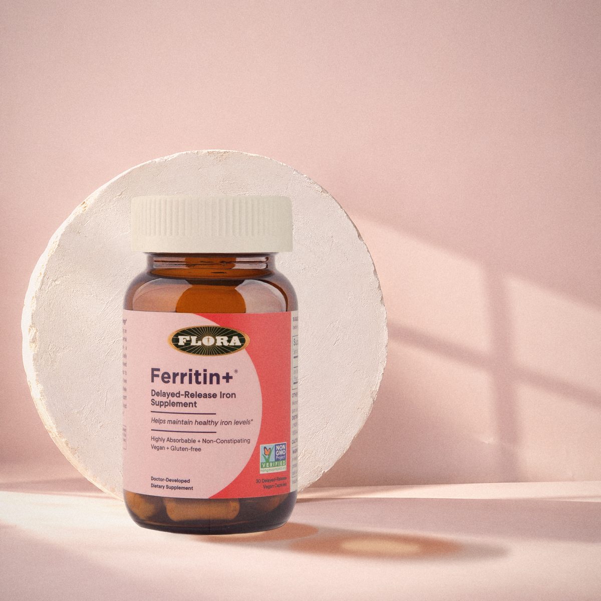 Ferritin+ bottle in front of a round plaster disc in window light